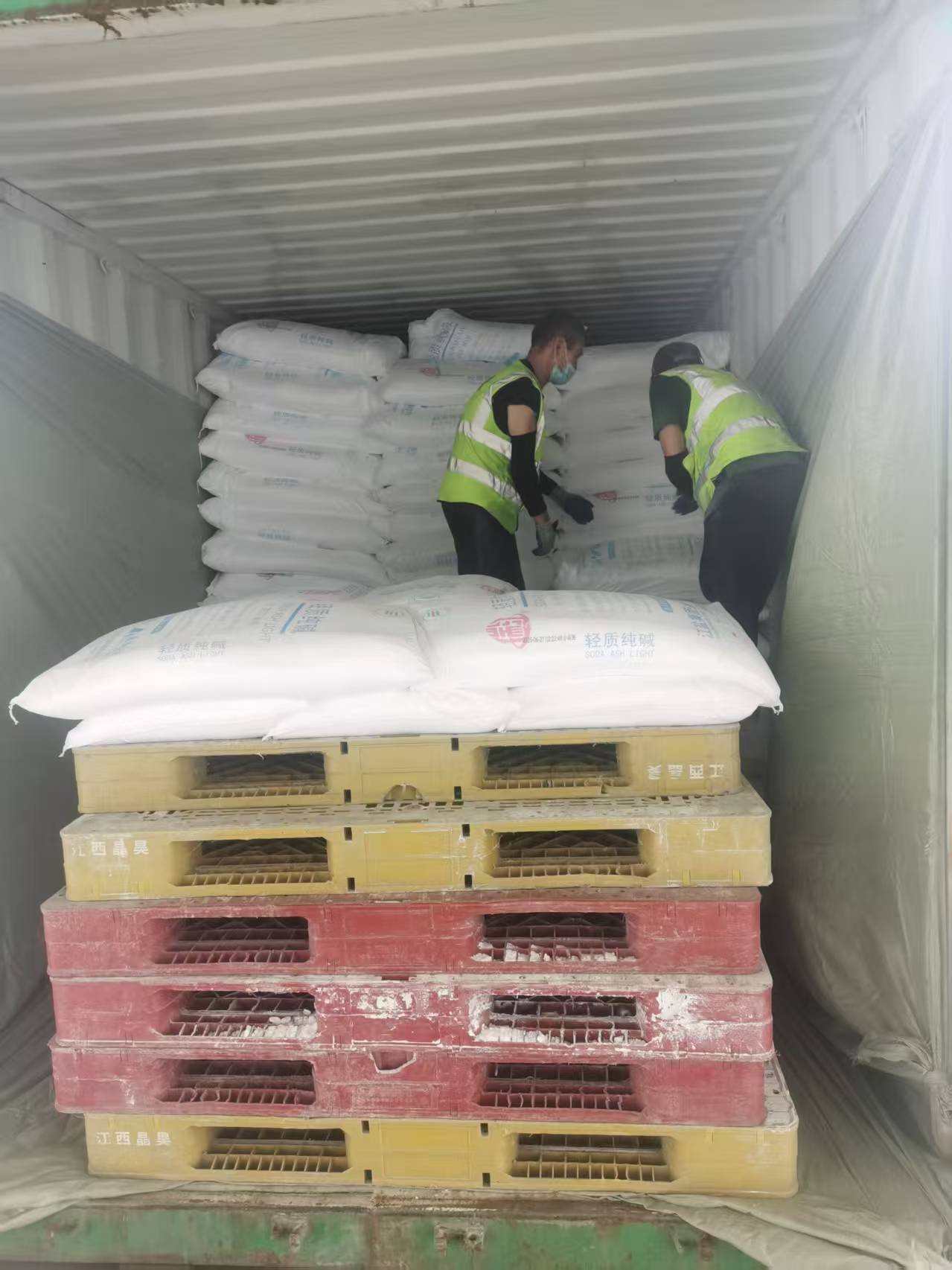 workers organize soda ash light in the container